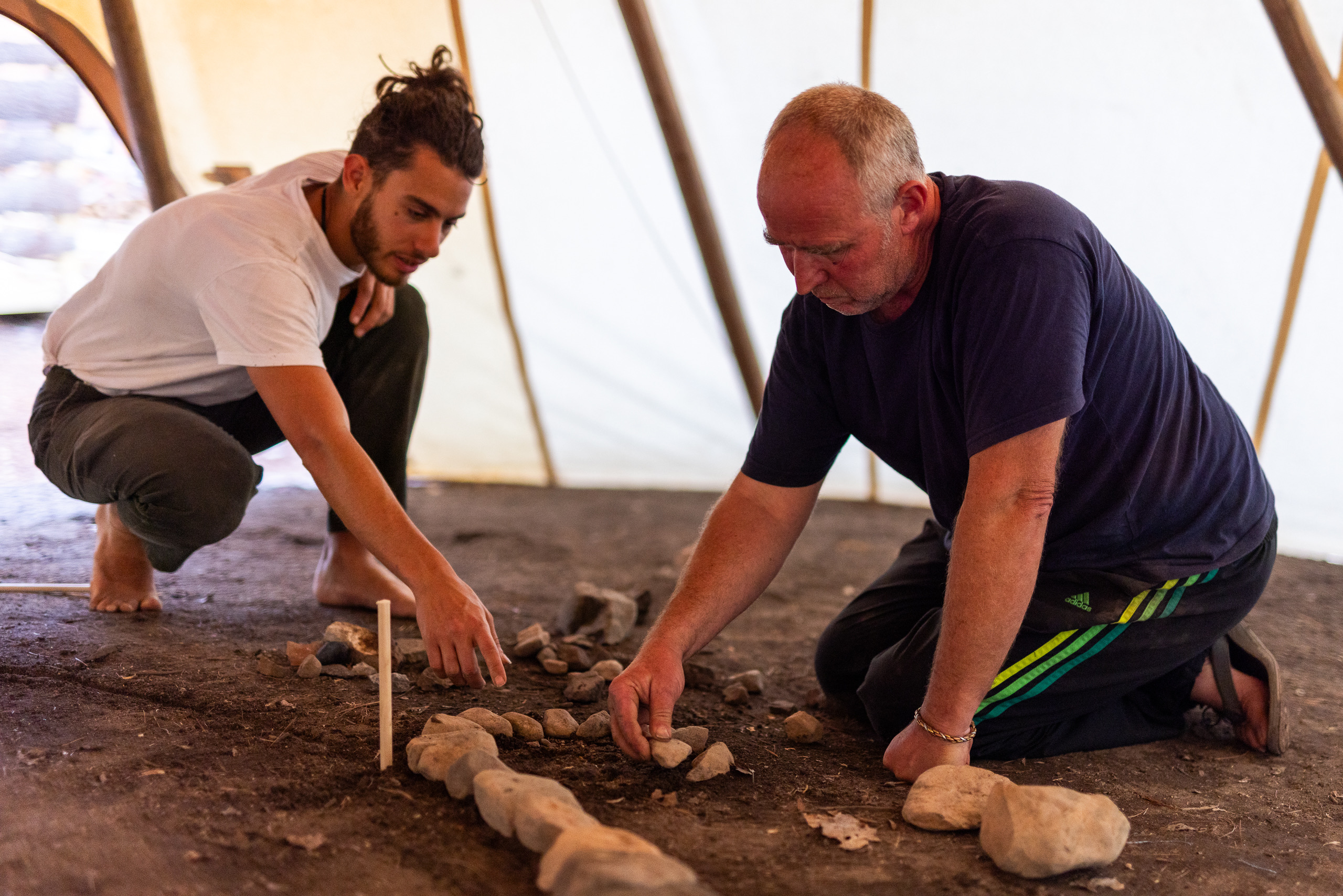Two men laying the first stones of the wheel