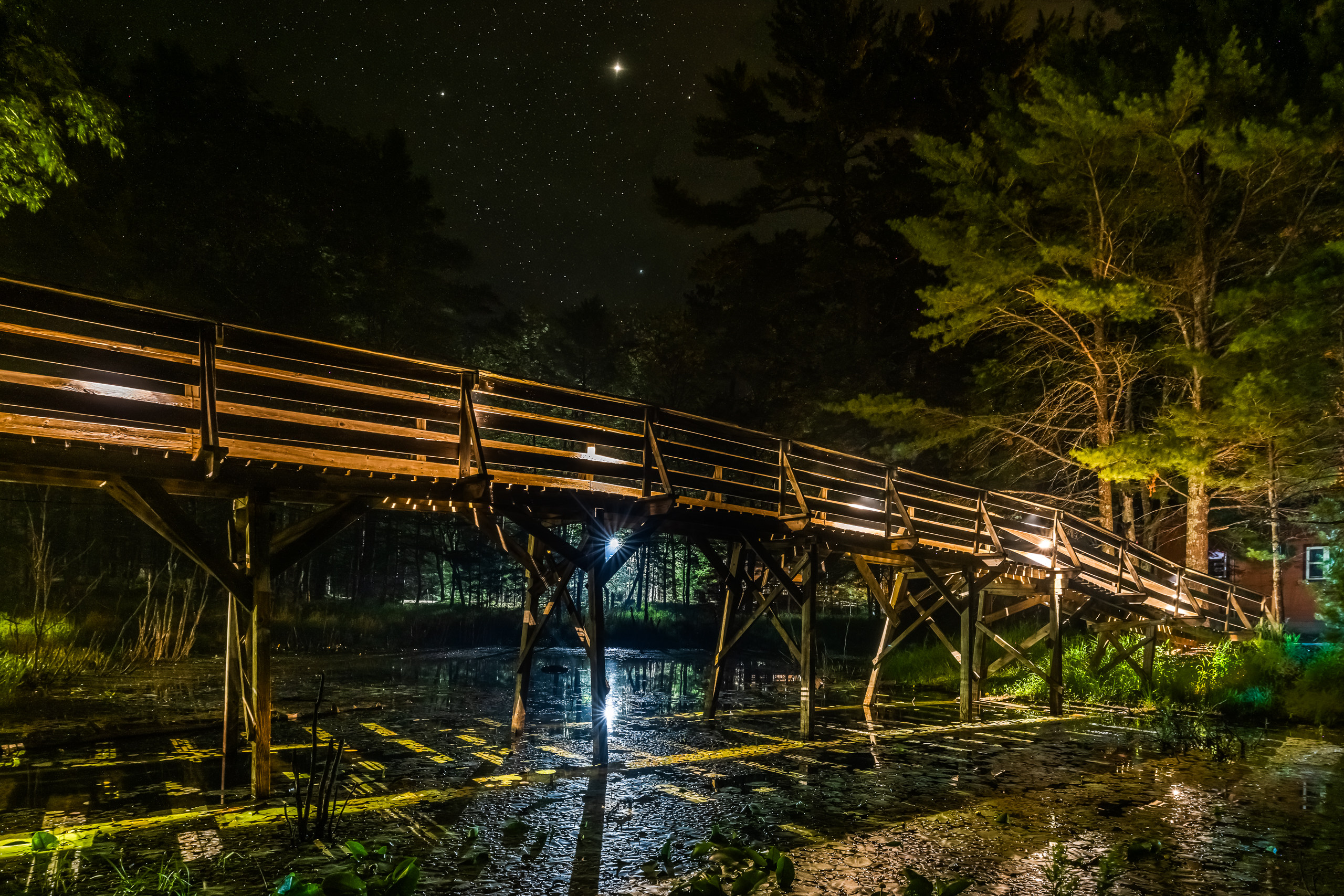 The camp bridge at night, lit from below